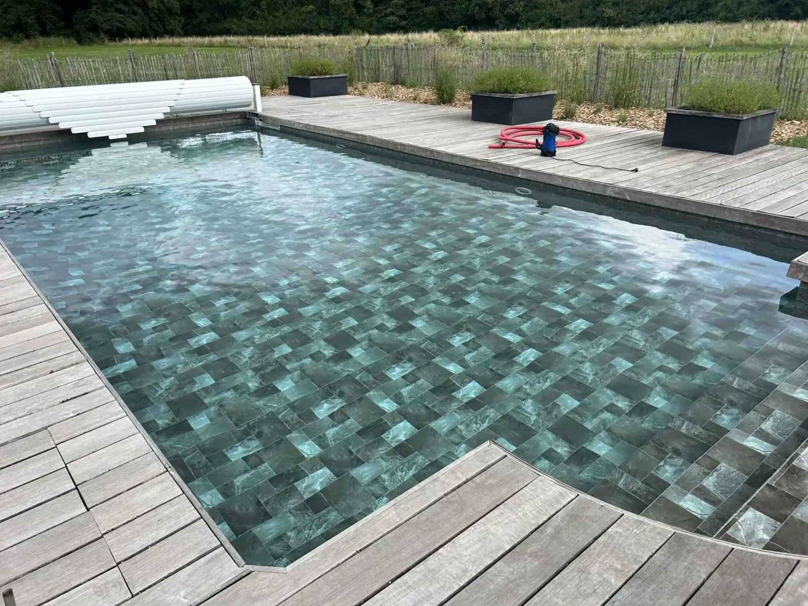 Piscine habillée d’une membrane à effet pierre, entourée d’une terrasse en bois