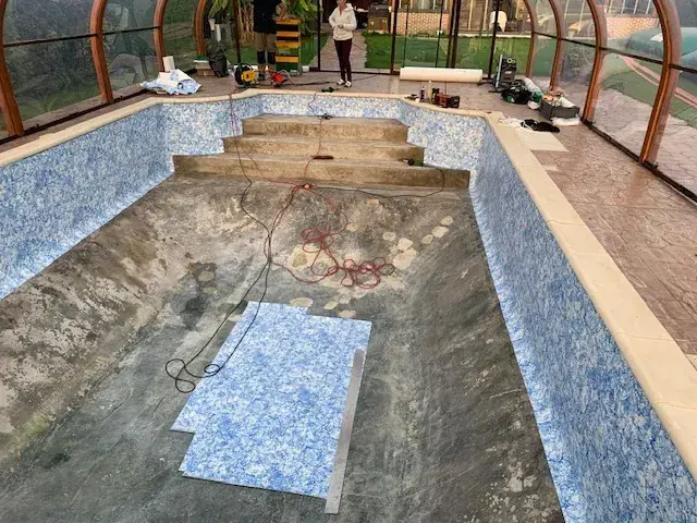 Bassin sous véranda en cours de chantier : parois habillées, fond en béton encore à nu
