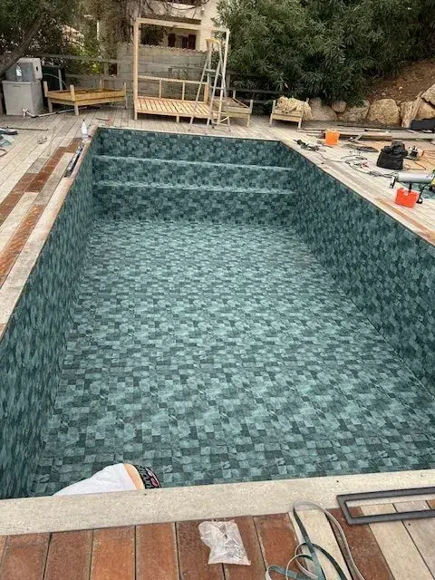 Membrane armée à motif pierre verte, soudée dans un bassin en fin de chantier